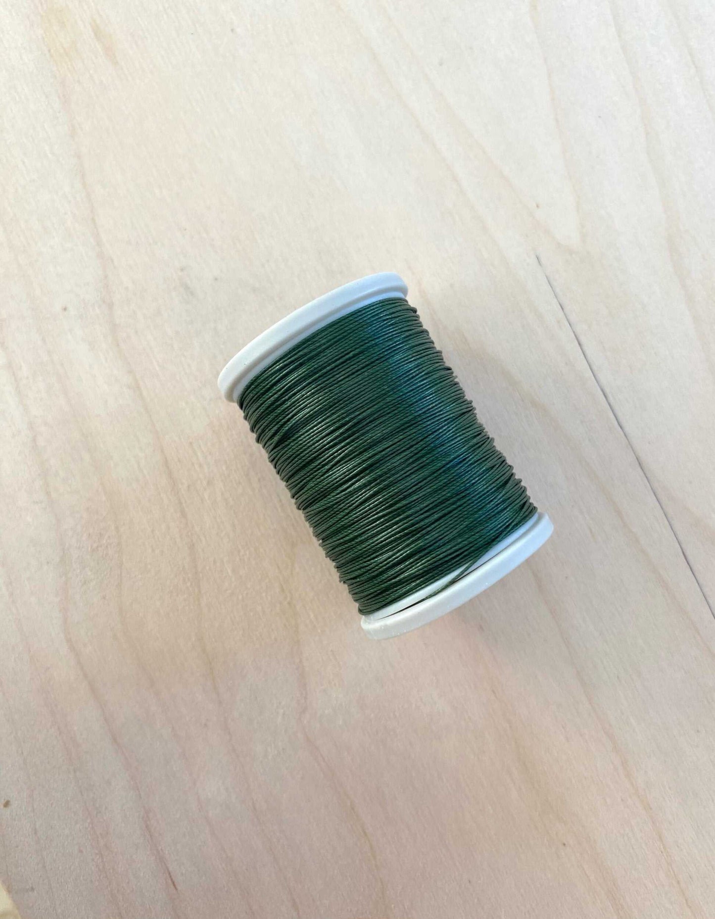 Green cotton linen thread spool, 0.55 mm diameter, 91.4 meters length.