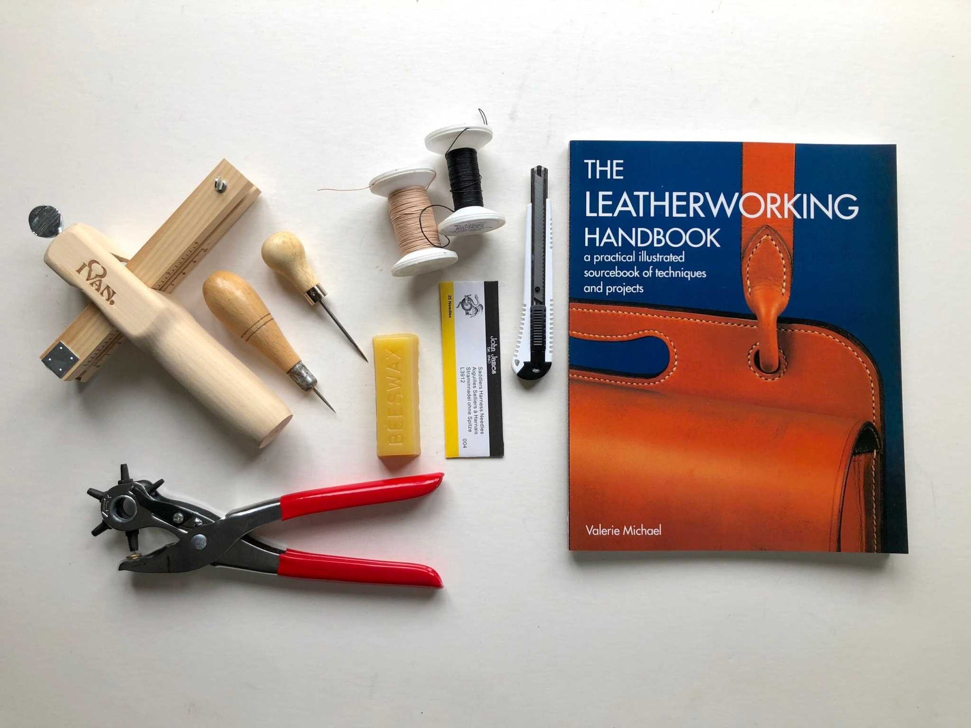 Leatherwork Starter Kit with tools, threads, and handbook by Valerie Michael on white surface.