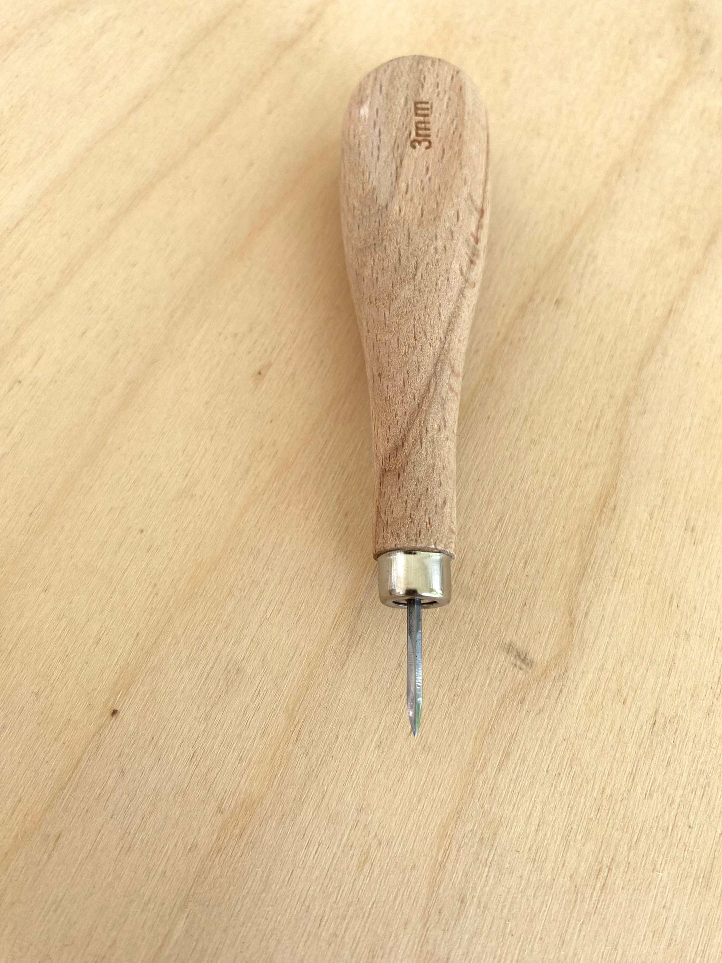 Economy Straight Blade Diamond Stitching Awl with wooden handle on a wooden surface.