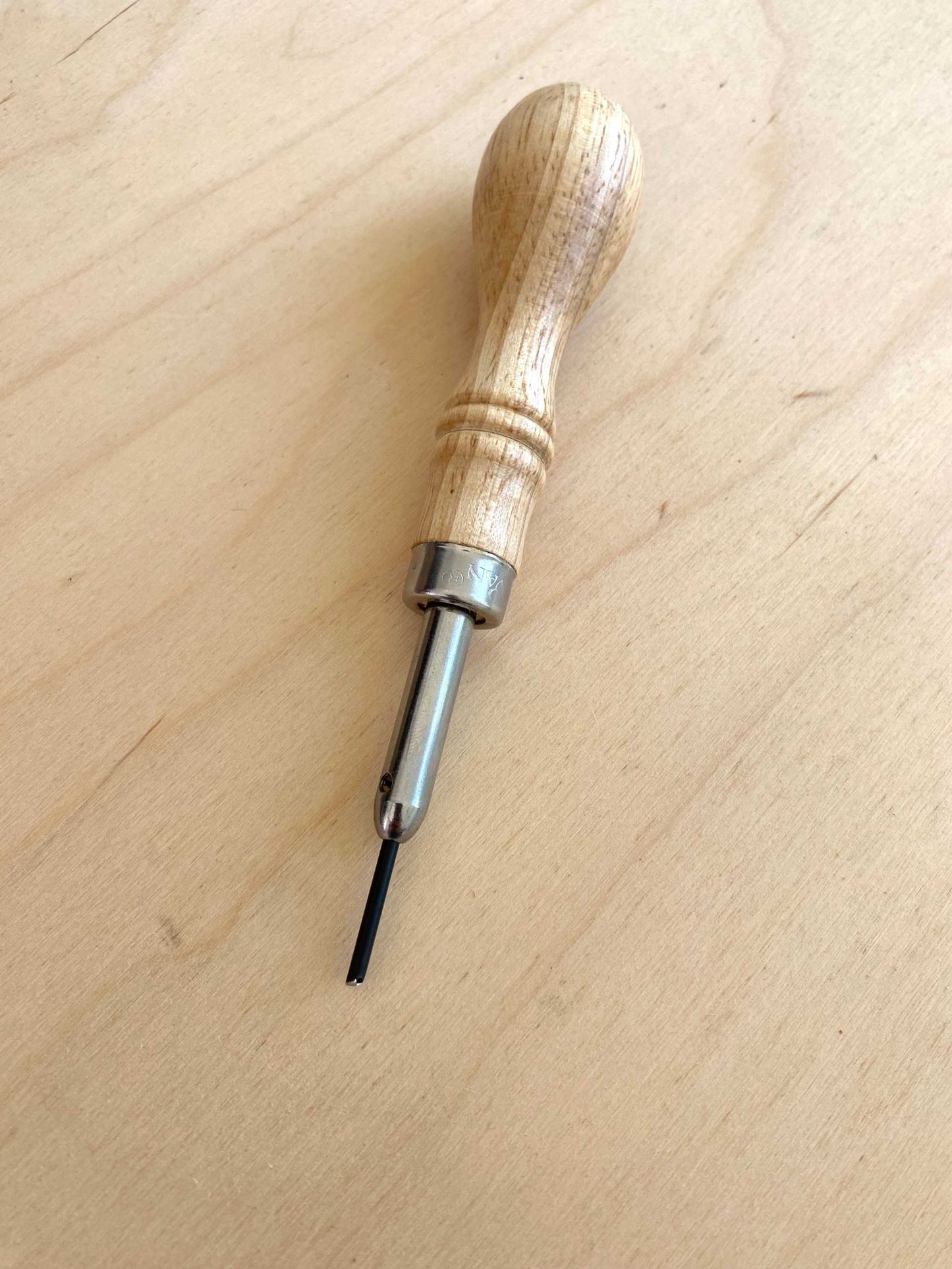 Free Hand Stitch Groove Awl with ergonomic wooden handle for leathercraft precision.