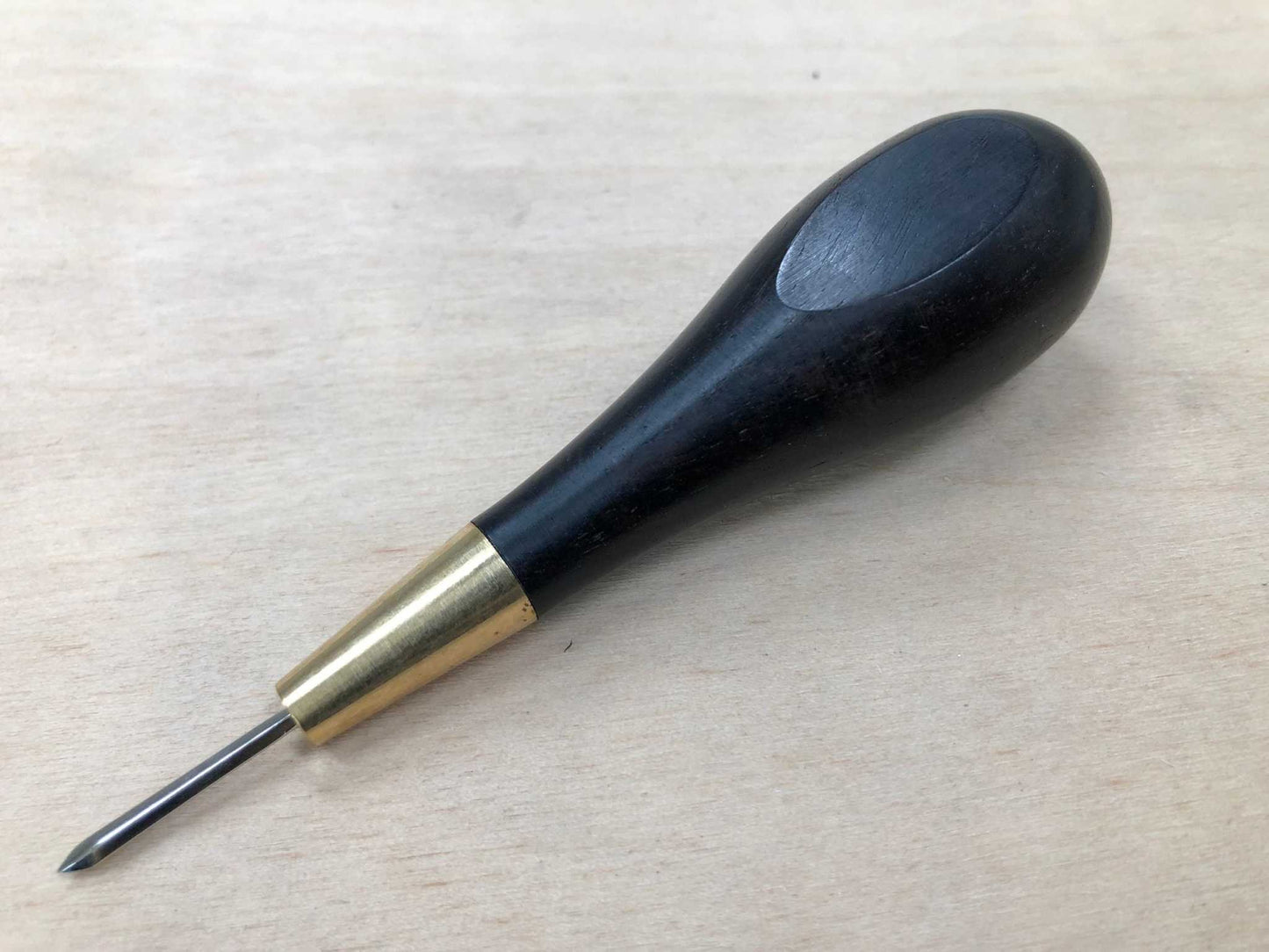 Ebony wooden handled stitching awl for precise leatherwork crafting.