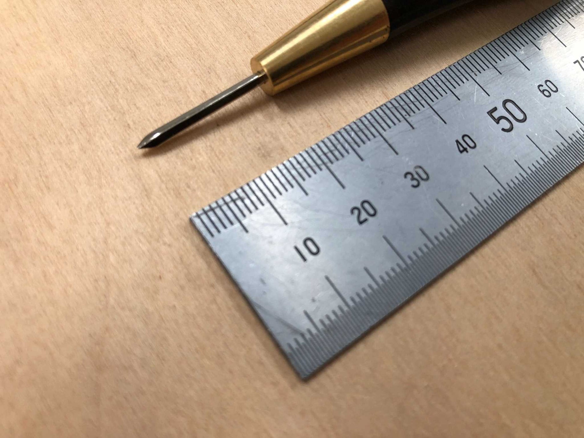 Wooden Handled Stitching Awl with ebony finish and ergonomic design next to a ruler.