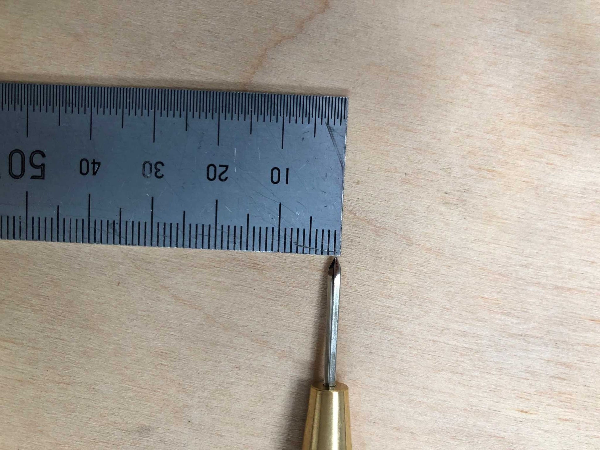 Wooden Handled Stitching Awl with ruler for size comparison.