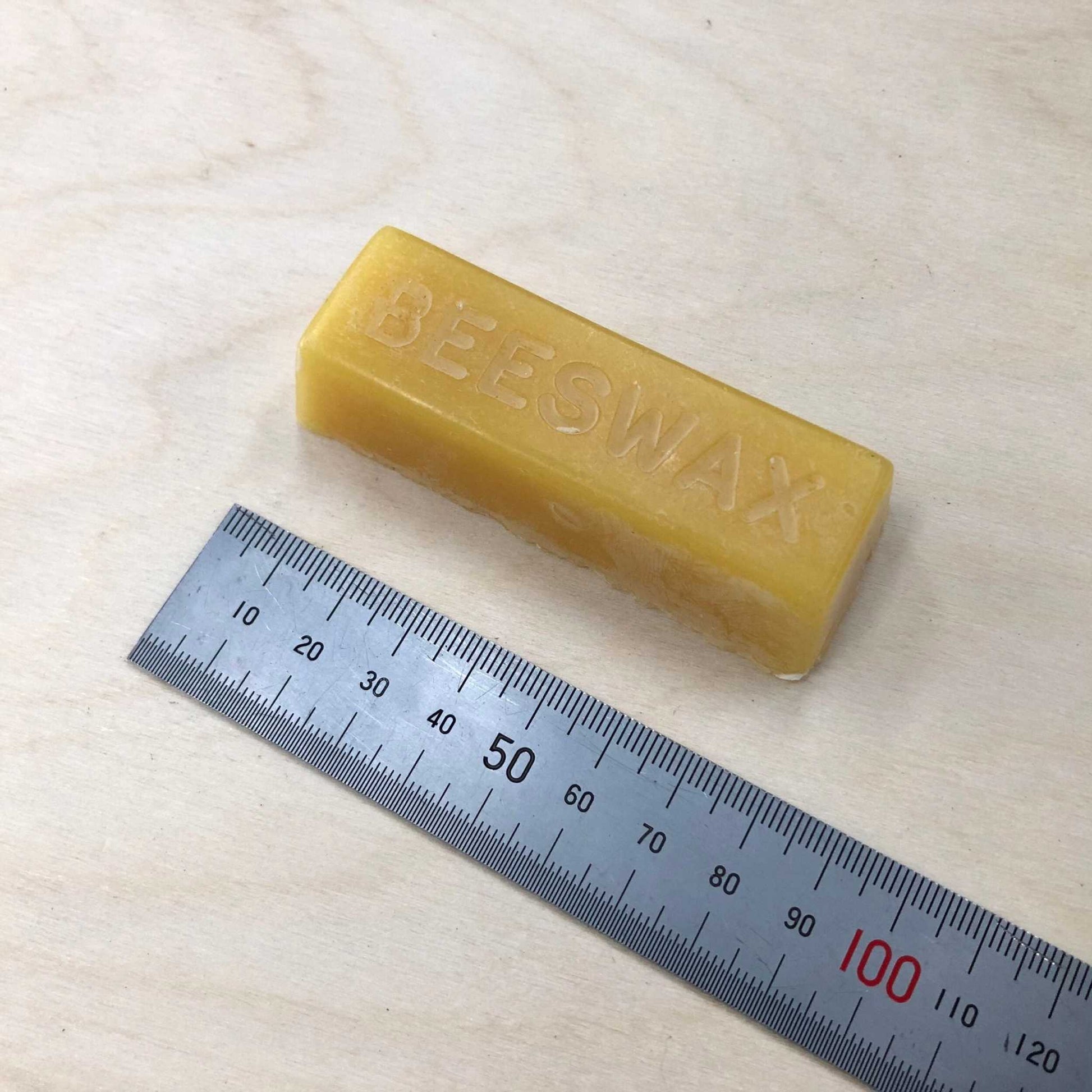 Large British Beeswax Block with ruler for scale, ideal for waxing leatherwork threads.