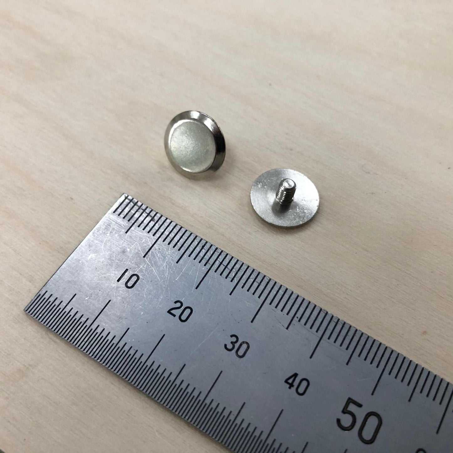 Chicago Screws in solid brass or nickel with ruler for scale, showcasing precision engineering for artisans and leatherworkers.