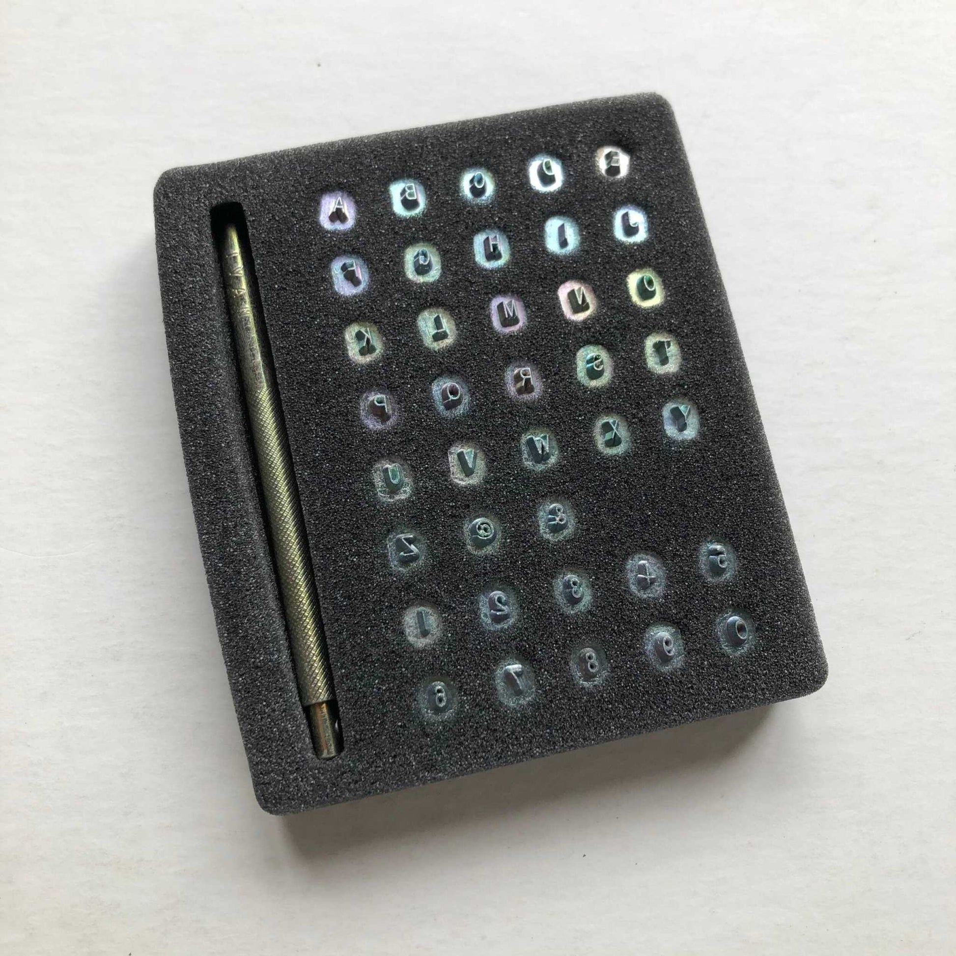 Alphabet Leather Embossing Stamp Set with full English alphabet, numbers, and stamping tool.