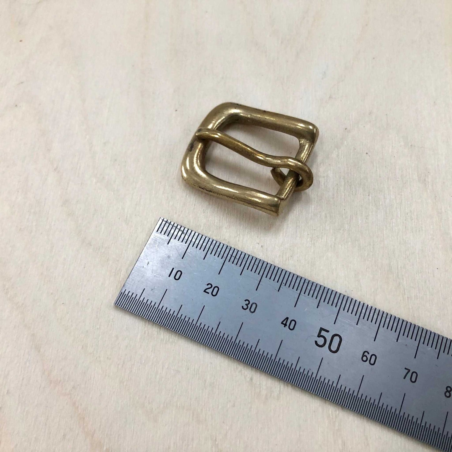 Solid Brass Belt Buckle with Rounded Frame and Pin, shown with measuring tape for size reference.